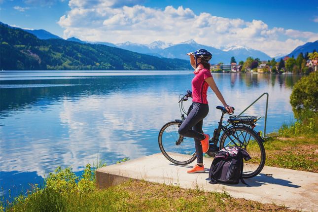 Foto: Frau mit E-Bike genießt den Blick über den See