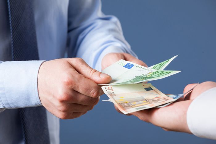 © zest_marina - stock.adobe.com Foto: zwei Hände übergeben Geldscheine in eine dritte Hand