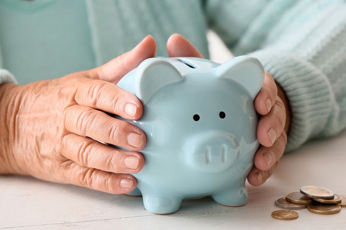 © Pixel-Shot - stock.adobe.com Foto: türkises Sparschwein zwischen alten Händen